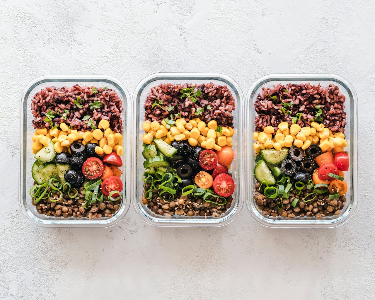 Pessoa planejando a alimentação com alimentos saudáveis e caderno