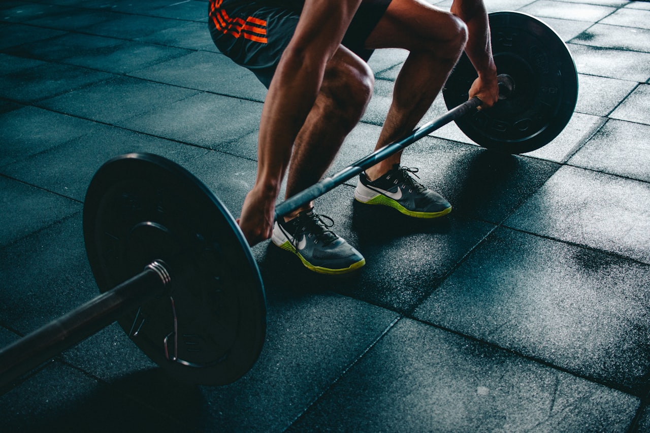 Atleta levantando barra com anilhas na academia
